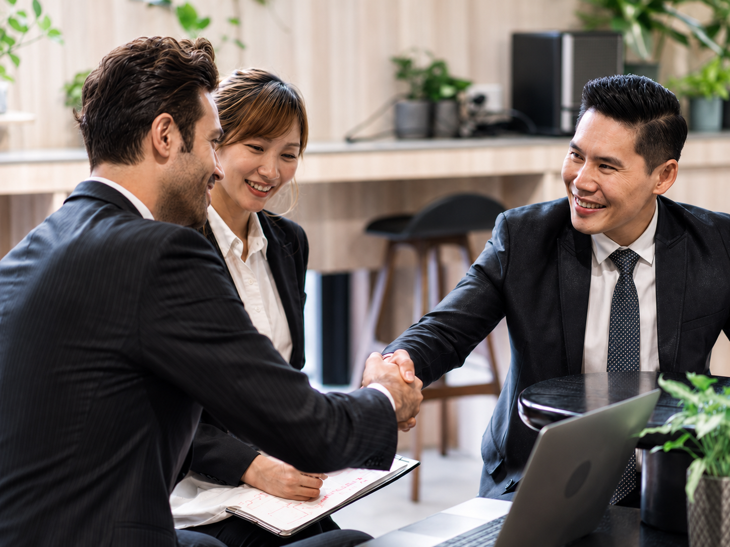 Business team celebrating a successful outreach agreement in a modern office